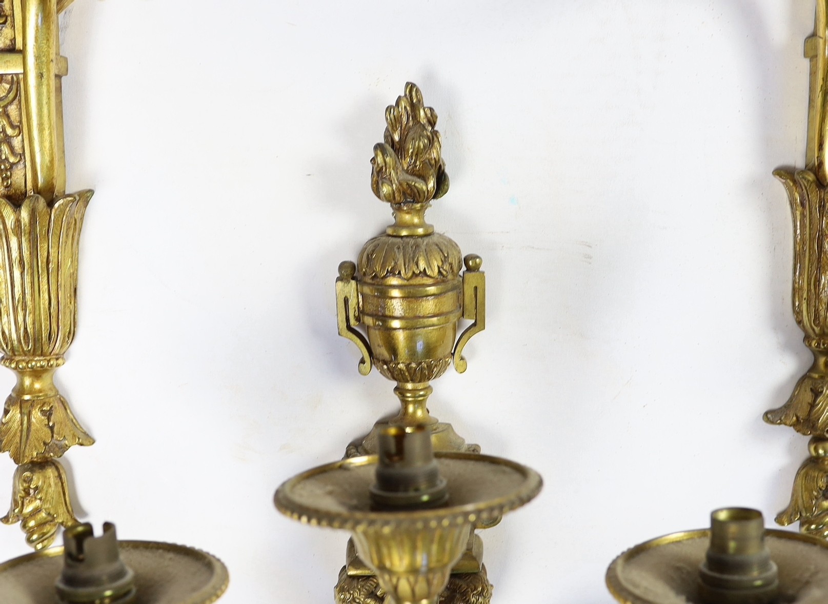 A set of eight cast gilt brass three branch wall sconces Height 23cm Width 22cm